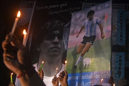Los fanáticos sostienen velas mientras rinden homenaje a la leyenda del fútbol argentino Diego Armando Maradona en Calcuta el 26 de noviembre de 2020