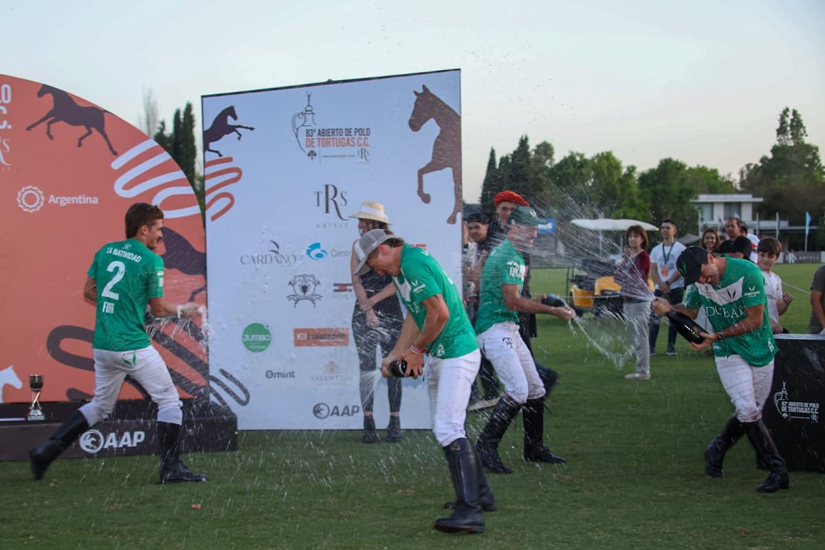 Los festejos de La Natividad tuvieron algunos ribetes de euforia; Camilo y Bartolomé (h.) Castagnola, Facundo Pieres y Pablo Mac Donough se bañan de espumante en el podio del Abierto de Tortugas.