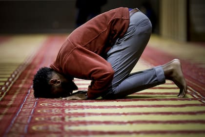 Los files rezan descalzos sobre alfombras muy cuidadas