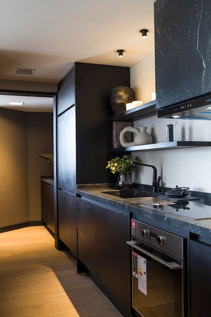 Los frentes de los muebles de cocina se hicieron en Rehau negro mate y el piso en 'Multiestrato Riverwashed' (Patagonia Flooring).