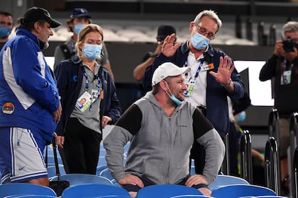 Los asistentes del torneo piden a los espectadores que abandonen el estadio debido a las restricciones de bloqueo de Covid-19, en medio del partido entre el serbio Novak Djokovic y Taylor Fritz de los EE. UU., en Melbourne.