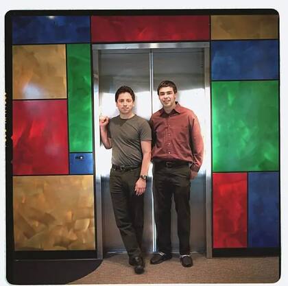 Los fundadores de Google, Sergey Brin (izq), y Larry Page, en el ascensor de la oficina de la empresa en Mt. View en 2003, rodeados por los colores que los identificarían desde la creación del logo 5 años antes