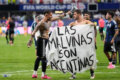 Los futbolistas Giovani Lo Celso y Nicolás Otamendi, junto a la pancarta con la frase "Las Malvinas son argentinas", tras la victoria ante Inglaterra en la semifinal del Mundial 2026