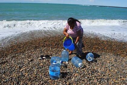 Los habitantes de Caleta Olivia deben cargar agua de mar en bidones para sobrellevar la situación