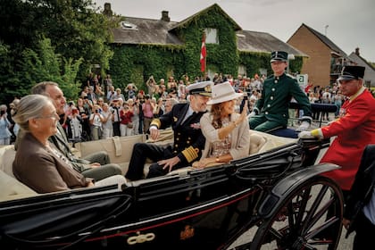 Los habitantes de Samsø saludan a los Reyes durante el paseo que hicieron en un carruaje antiguo por las calles de la isla, junto al alcalde Marcel Meijer y su mujer, Kirsten OEstergaard Meijer, el 28 de agosto pasado