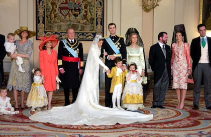 Los hijos de la infanta Elena, Felipe y Victoria Federica, posan con los novios y los reyes eméritos. El menú del banquete nupcial, del restaurante Jockey (que llevaba 18 años sirviendo las cenas de gala en el Palacio Real), consistió en entrantes variados, con jamón de Jabugo, queso manchego con regañadas, tartaletas de 'esqueixada', canapés de gamonedo con manzanas, 'mousse' de pescado de roca, patatas rellenas de changurro, vieiras fritas empanadas, tostas de champiñón, puntas de espárragos verdes fritas y tirabuzones de lenguado. Eso de aperitivo. De comida, tartaleta de hojaldre con frutos de mar y capón asado en tomillo, frutos secos, tarta (de dos metros de altura) y café. Los vinos, españoles, blanco Rías Baixas y Rioja Gran Reserva de 1994