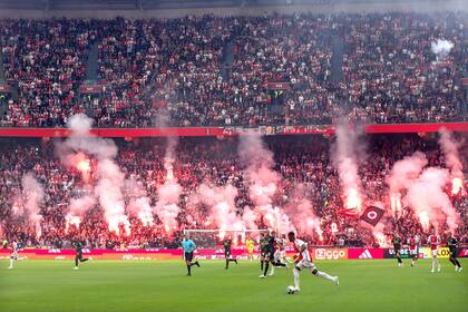 Los hinchas de Ajax encienden fuegos artificiales, en el comienzo de los incidentes que llevaron a la suspensión del partido ante Feyenoord