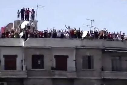 Los hinchas de Al-Ittihad, de Siria, festejan en la terraza de un edificio de Aleppo el primer gol de su equipo, en la reanudación de la liga de ese país.