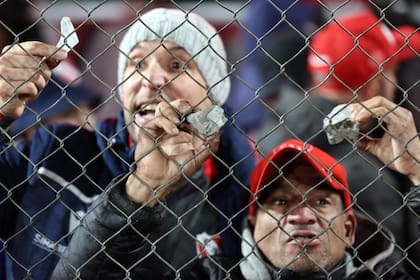 Los hinchas de Independiente muestran piedras que les arrojaban los chilenos desde la tribuna superior