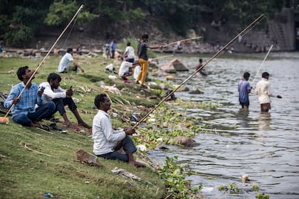 Los hombres pescan a lo largo de las orillas del río Yamuna en Nueva Delhi, India, el 25 de junio de 2020