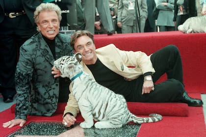 Los ilusionistas Siegfried Fischbacher y Roy Uwe Ludwig Horn posan para los fotógrafos con un cachorro de tigre blanco, después de que dieron a conocer a su estrella en el Paseo de la Fama de Hollywood