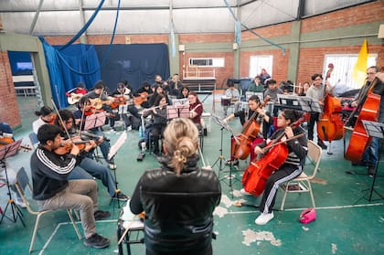 Los integrantes de la Orquesta Ópera Villera ensayan bajo la dirección de Mailén Ubiedo Myskow en el Bajo Flores, donde el proyecto ofrece formación musical gratuita a niños y jóvenes