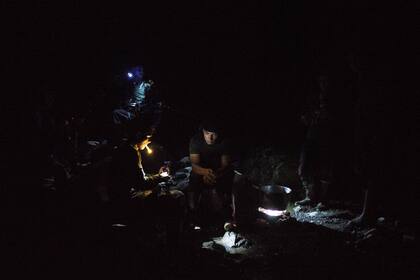 Los integrantes del nuevo frente de las FARC cenan a la luz de las lámparas