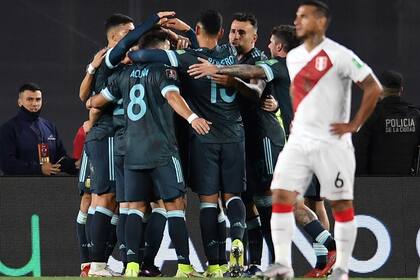 Los jugadores argentinos festejan junto a Lautaro Martínez, autor del primer gol ante Perú; lo sufre Miguel Trauco, en primer plano.