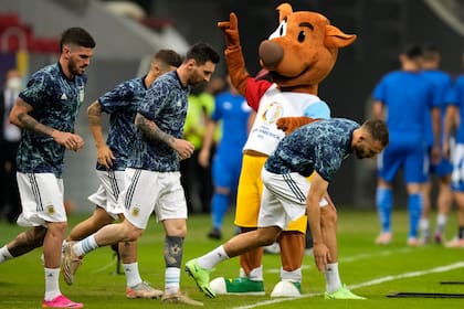 Los jugadores de Argentina ingresan en la cancha para calentar, frente a Pibe, la mascota de la Copa América: la selección tuvo dos caras, una vez más, en el triunfo ante Paraguay (AP Foto/Ricardo Mazalan)