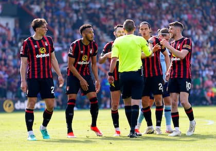 Los jugadores de Bournemouth rodean al árbitro Matt Donohue tras pitar un penal en el partido contra Brentford en la Premier League de mayo pasado