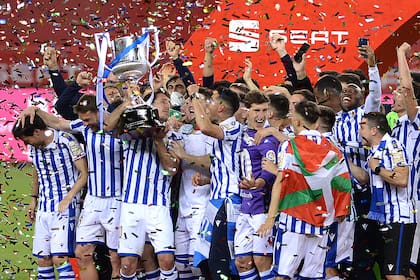 
Los jugadores de la Real Sociedad celebran con el trofeo tras ganar la final de la Copa del Rey de España 2020 entre el Athletic de Bilbao y la Real Sociedad en el estadio La Cartuja de Sevilla el 3 de abril de 2021.
CRISTINA QUICLER / AFP