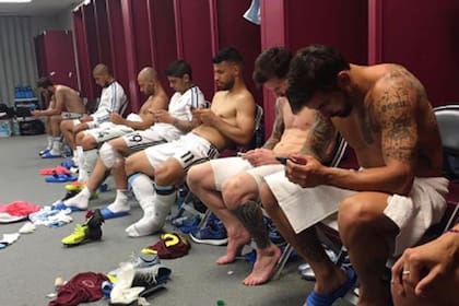 Una imagen de otros tiempos de la selección, con los jugadores atentos a sus celulares en el vestuario después de un partido