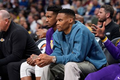 Los jugadores de los Lakers de Los Ángeles Russell Westbrook, al frente, y Malik Monk miran desde la banca en la primera mitad del juego de baloncesto de los Lakers contra los Nuggets de Denver el domingo 10 de abril de 2022 en Denver. (AP Foto/David Zalubowski)