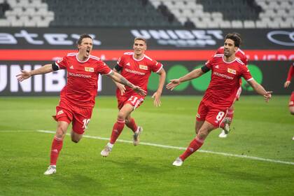 Los jugadores de Union Berlin, izquierda a derecha, Max Kruse, Robin Knoche y Rani Khedira festejan el gol de Kruse contra Borussia Moenchengladbach en partido por la Bundesliga en Moenchengladbach, Alemania, sábado 22 de enero de 2022. Union ganó 2-1. (Bernd Thissen/dpa via AP)