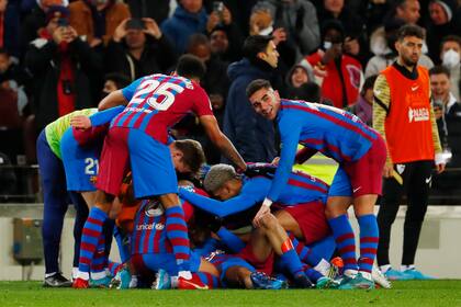 Los jugadores del Barcelona celebran el gol de Pedri en el partido contra el Sevilla en la Liga española, el domingo 3 de abril de 2022. (AP Foto/Joan Monfort)