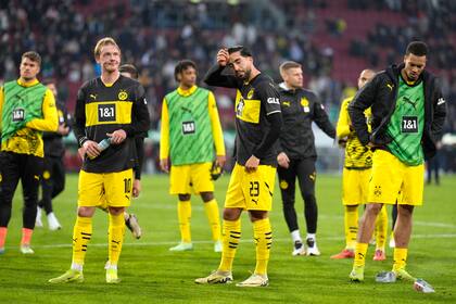 Los jugadores del Borussia Dortmund se paran en el campo abatidos al final del partido de fútbol de la Bundesliga entre el FC Augsburgo y el Borussia Dortmund en el WWK-Arena, Augsburgo, Alemania, el sábado 26 de octubre de 2024. (AP Foto/Matthias Schrader)
