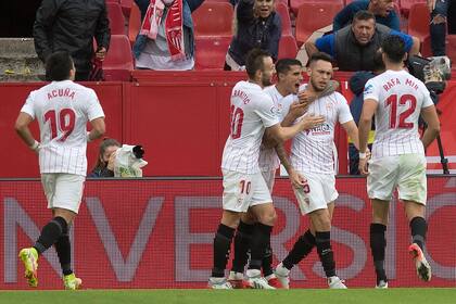 Los jugadores del Sevilla se suman para abrazar a Lucas Ocampos, autor del segundo tanto ante Osasuna en el Ramon Sanchez Pizjuan