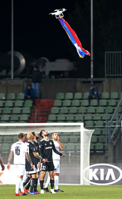 Los jugadores observan en lo alto el dron con la bandera armenia