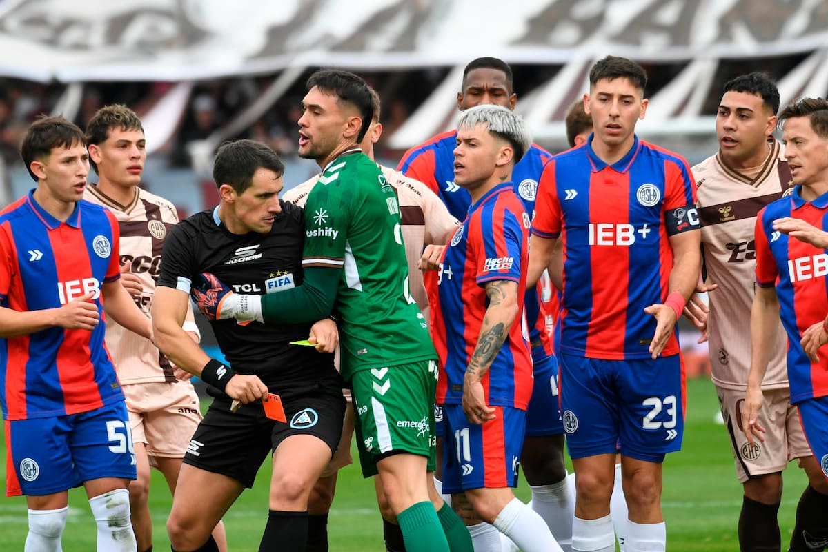 Los jugadores rodean al árbitro Sebastián Martínez Beligoy durante un partido entre Platense y San Lorenzo; el referato argentino vive rodeado de sospechas
