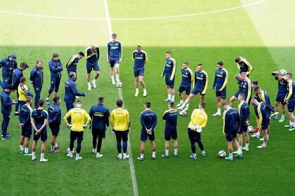 Los jugadores ucranianos forman un círculo durante un entrenamiento en el estadio Cardiff City en Cardiff, Gales, sábado 4 de junio de 2022. Ucrania enfrenta a Gales el domingo por la clasificación al Mundial de Qatar. (Mike Egerton/PA via AP)