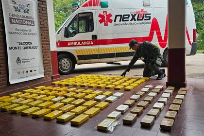 Los ladrillos de cocaína con la marca del Delfín y, en el fondo, la ambulancia en la que estaban ocultos, en tránsito de Salta a Buenos Aires
