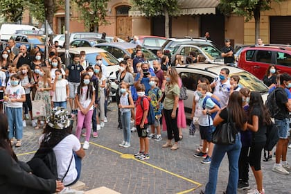 Los maestros saludan a los alumnos y a los padres con una mascarilla cuando llegan el 14 de septiembre de 2020 para el inicio del año escolar en la escuela secundaria técnica Luigi Einaudi en Roma