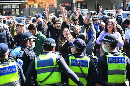 Los manifestantes antibloqueo protestan en el mercado Queen Victoria de Melbourne durante un mitin el 13 de septiembre de 2020, en medio de la pandemia de coronavirus