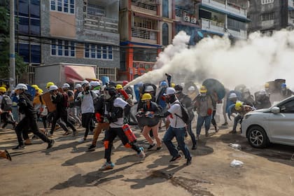 Los manifestantes corren en la ciudad de  Yangon, Myanmar, tras una embestida de las fuerzas de seguridad