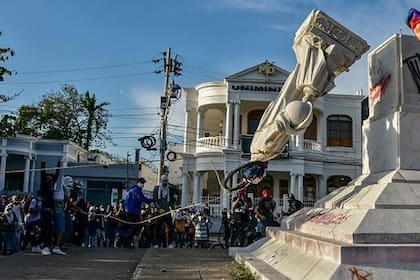 Los manifestantes derriban una estatua de Cristóbal Colón durante una manifestación contra el gobierno en Barranquilla, Colombia
