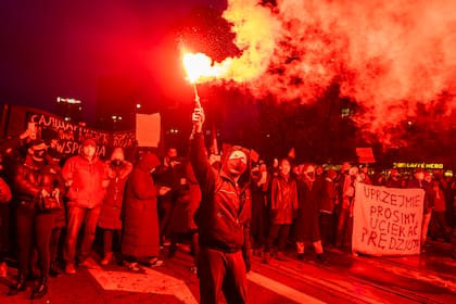 Los manifestantes encienden bengalas mientras participan en una protesta a favor del aborto en el centro de Varsovia, el 28 de noviembre de 2020, como parte de una ola nacional de protestas desde el 22 de octubre contra la prohibición casi total del aborto en Polonia