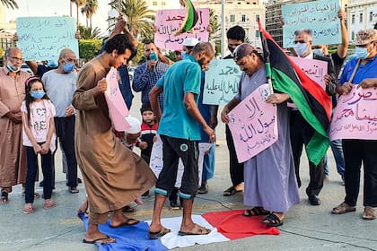 Los manifestantes pisaron una bandera nacional francesa durante una protesta contra los comentarios del presidente francés Emmanuel Macron sobre las caricaturas del profeta Mahoma, en la Plaza de los Mártires de la capital de Libia, Trípoli, el 25 de octubre de 2020