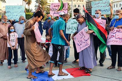 Los manifestantes pisaron una bandera nacional francesa durante una protesta contra los comentarios del presidente francés Emmanuel Macron sobre las caricaturas del profeta Mahoma, en la Plaza de los Mártires de la capital de Libia, Trípoli, el 25 de octubre de 2020