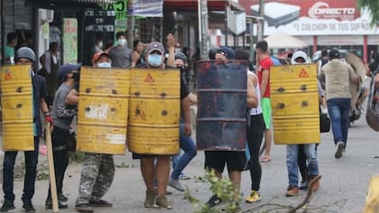 Los manifestantes recurren a escudos improvisados para hacer frente a la policía.