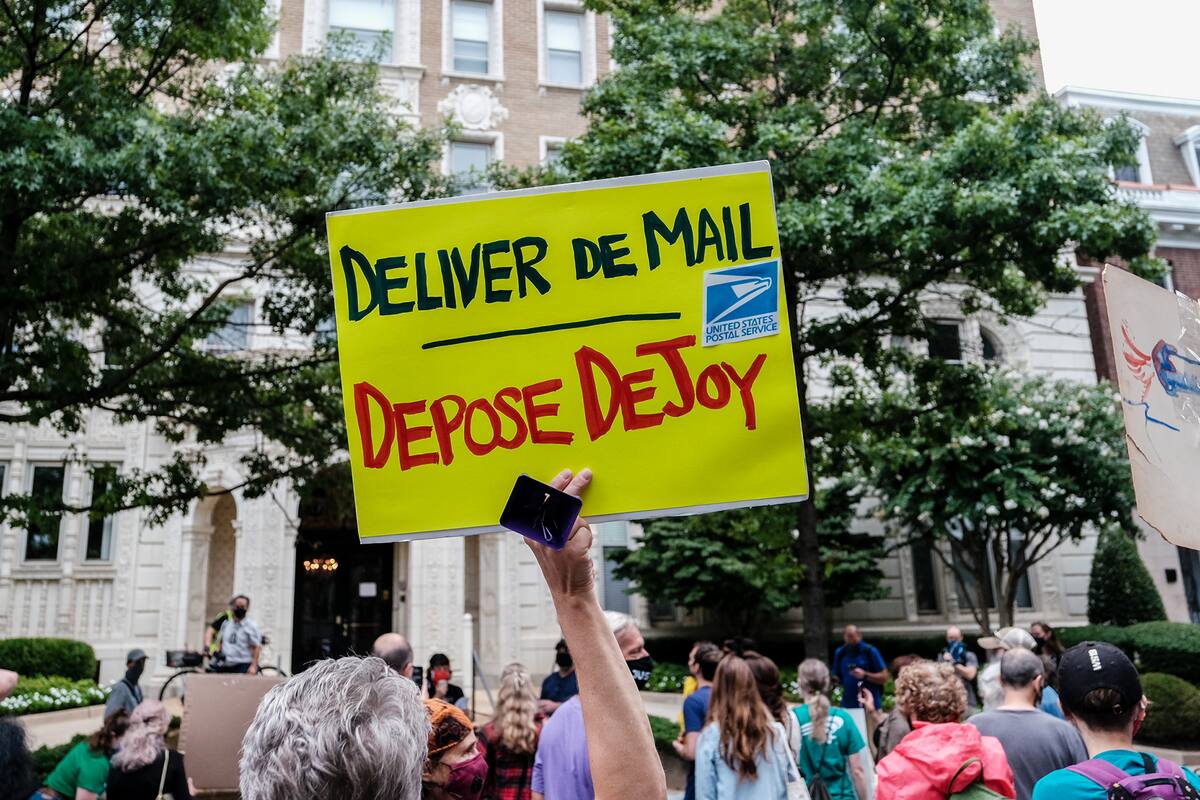 Los manifestantes se reúnen fuera del condominio del actual director general de correos de Estados Unidos Louis Dejoy el 15 de agosto de 2020 en Washington, DC