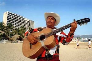 Los mariachis se asolean en las arenas de Acapulco para alegrar la estada de sus visitantes, que llegan a tres millones