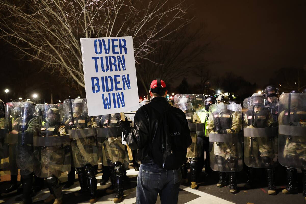Los miembros de la Guardia Nacional y la policía mantienen a un pequeño grupo de manifestantes lejos de la capital después de que miles de partidarios de Donald Trump irrumpieran en el Capitolio de Estados Unidos el 6 de enero de 2021 en Washington, DC