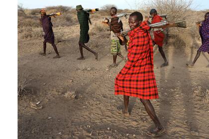 Los miembros de la tribu Turkana caminan con armas para proteger a su ganado de las tribus rivales Pokot y Sambur cerca de Baragoy, Kenia