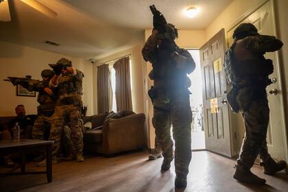 Los miembros del Equipo de Respuesta Especial del Servicio de Inmigración y Control de Aduanas (ICE, por sus siglas en inglés) demuestran cómo ingresar a una vivienda en un allanamiento, en los Centros Federales de Capacitación para el Cumplimiento de la Ley (FLETC) en Brunswick, Georgia, el 21 de agosto de 2025. (AP Foto/Fran Ruchalski)
