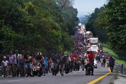 Los migrantes caminan por la carretera hacia el municipio de Escuintla, estado de Chiapas, México, la madrugada del jueves 28 de octubre de 2021, mientras continúan su viaje hacia los estados del norte de México y la frontera con Estados Unidos. (AP Foto/Marco Ugarte)