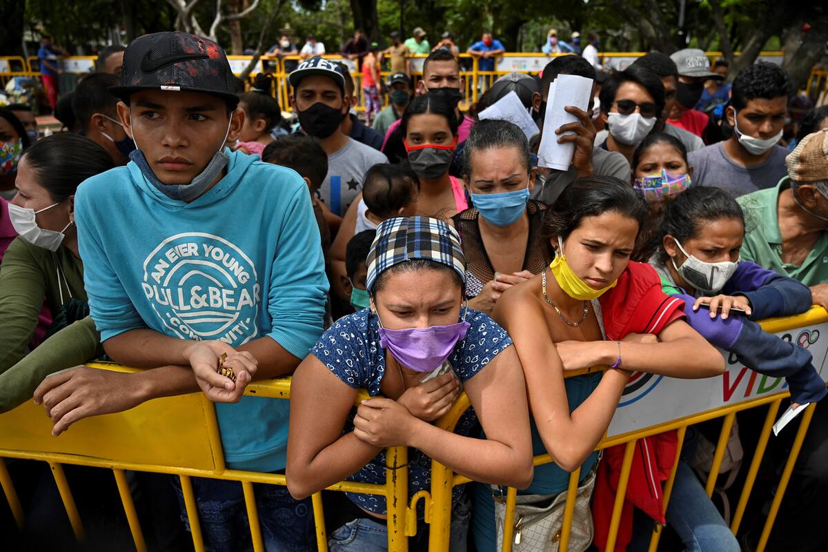 Los migrantes venezolanos que desean regresar a su país debido a la nueva pandemia de coronavirus, esperan en Cali, Colombia, la oportunidad de subir a un autobús que los llevará a la frontera, el 12 de mayo de 2020