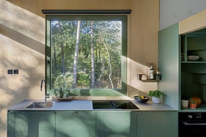 Los muebles de cocina quedan visualmente ligados al bloque de descanso y baño, lo que ordena la planta y suma una sensación de mayor amplitud.