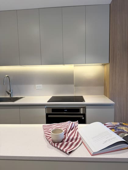 Los muebles suelen ser la mayor inversión y también lo que más demora. En compensación, aquí ganaron tiempo con los pisos vinílicos con sistema click, que aceleró mucho el proceso de colocación. Mesada de Silestone, amoblamiento y alacenas hechos a medida en melamina 'Gris ceniza' (Faplac).