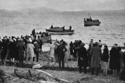 Los náufragos del Monte Cervantes, recién llegados a las costas de Ushuaia, observan cómo llegan en los botes salvavidas los elementos rescatados del barco