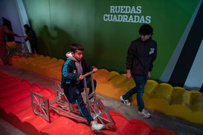 Los niños andan en bicicletas de ruedas cuadradas